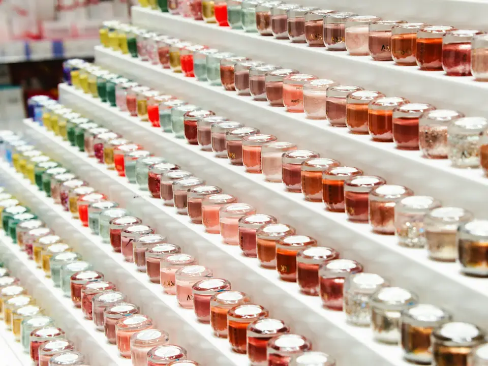Expositor iluminado con filas de frascos de cosmética