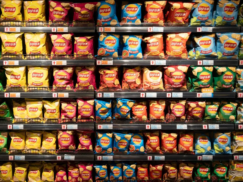 Lineal de supermercado con varias baldas de producto de aperitivo ordenado